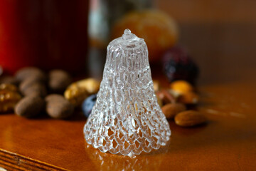 Wall Mural - Glass bell on the table against a background of dried fruit