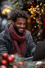 A smiling man making a video call on his laptop, enjoying long-distance communication during the festive season.