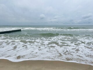 Wall Mural - cloudy grey seascape, waved sea horizon, windy at the sea, empty beach