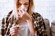 © Prostock-studio - Disease treatment concept. Woman wipes nose and looks at temperature