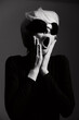 © SHOTPRIME STUDIO - Surprised woman with short hair wearing oversized sunglasses, expressing shock or excitement, against a dark monochromatic background. Fashion and emotion concept.