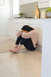 © Wavebreak Media - Young woman sitting on kitchen floor, feeling overwhelmed and contemplative, at home