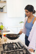 © Wavebreak Media - Asian woman cooking vegetables in modern kitchen, enjoying culinary activity, at home