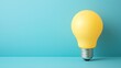 © somneuk - A bright yellow light bulb stands against a turquoise background, symbolizing creativity and innovative ideas.