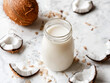 © Rongh Studio - Coconut milk in a glass jar with a coconut shell on a white marble table