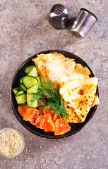 Poster - Thin pancakes or crepes with smoked salmon, cucumber and dill on a gray background.