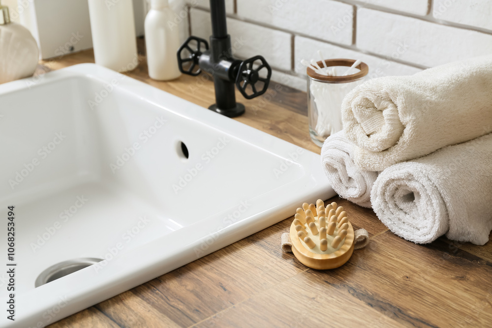 Bath supplies and sink on table  in bathroom