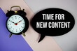 © may1985 - Time For New Content text on speech bubble with alarm clock top view on purple geometric background