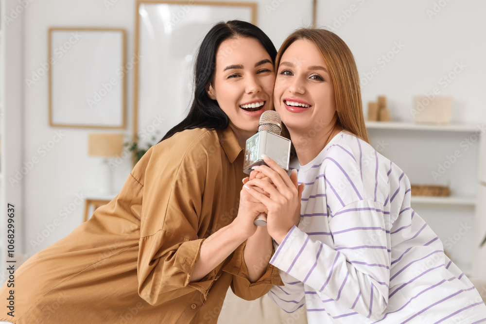 Beautiful young women with microphone singing karaoke at home