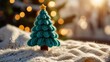 © Vitalii - Small knitted christmas tree stands on soft blanket with christmas lights in background