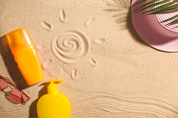 Wall Mural - Hat, sunglasses and bottles of sunscreen cream on sand as background