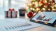 © AucArtStudio - A tablet displaying graphs sits on a table alongside festive decorations, a coffee cup, and a gift box, evoking a holiday business atmosphere.