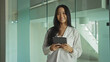 © Krakenimages.com - Attractive, young, asian, woman, standing, indoors, workplace, holding, tablet, smiling, confidently.