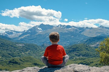 A young boy is sitting on a rock in the mountains, looking out at the beautiful landscape. Concept of peace and tranquility, as the boy takes in the breathtaking view of the mountains