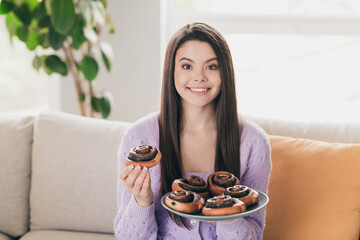 Wall Mural - Photo of nice young teen girl hold plate bun eating wear violet clothes enjoy modern cozy bright interior flat indoors