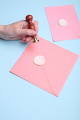 Sticker - Girl sealing envelope with wax sealing stamp on blue background