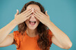© Lucia PSV - Young pretty woman isolated over blue background. Hiding her eyes with her hands while smiling. Shyness. Embarrassment. Introversion, fear. She is going to get a surprise that will make her very happy