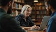 © Natalya - Elderly woman attentively engaging with a laptop in a library setting, reflecting lifelong learning