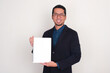 © KrishnaTedjo - A man wearing suit smiling happy while holding blank white paper