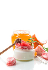 Poster - homemade sweet yogurt in a glass jar with pieces of red ripe grapefruit and honey, isolated on white background