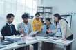 © Wicitr - Collaborative Brainstorming: A diverse team of professionals huddle around a laptop, engaged in a lively discussion, fueled by ideas and a shared goal.  The office setting.