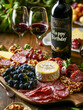 © DrCreative - Elegant birthday setup featuring a charcuterie board with meats, cheeses, grapes, and a 'Happy Birthday' wine bottle, perfect for celebrations