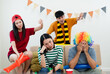 © PhugunStock - A group of Asian male and female friends watch the live broadcast of the World Cup match on television. Share a beer and snacks together at home. Sports fans feel sad when the team they support loses.