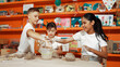 © InfiniteFlow - Handsome student dipping hand in to water to soften clay at art classroom. Group of diverse children working or modeling vase. Happy boy put water to young girl while laugh with happy. Edification.