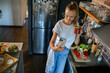 © Geber86 - Young woman filming cooking tutorial in kitchen with fresh vegetables and eggs
