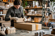 © BOONJUNG - designer carefully assembling custom cardboard box in creative workspace