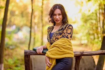 the beautiful brunette a blanket and a book in the forest during autumn