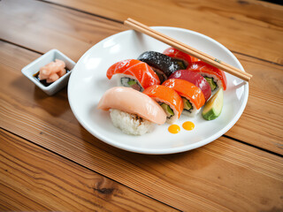 Fresh sushi platter featuring colorful rolls on a wooden table with chopsticks and garnishes in a vibrant setting