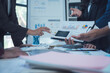 © Kritdanai - Strategic Business Meeting: Hands-on analysis of financial charts and graphs during a collaborative business meeting.  Focus on teamwork and data-driven decision-making.