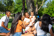 © Arianne - Latin multigenerational family spending a sunny day together in a park