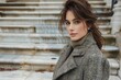 © Inna - A young woman stands elegantly on marble steps, wearing a fashionable coat and a cozy turtleneck. Her hair is styled loosely, giving a relaxed yet chic look. The scene reflects an autumn ambiance