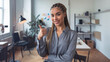 © Tom - A young woman of mixed ethnicity with braided hair gives a thumbs up in a bright, contemporary office setting, exuding confidence and positivity.