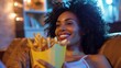 © iuricazac - Bright and happy, a woman smiles while eating French fries on the sofa.