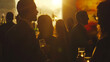 © ElenPI_K - Silhouetted people socializing with drinks at sunset-lit event