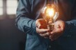 © Isuru - Business man holding light bulb for new idea innovation.