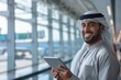 © Isuru - Young Arab businessman with tablet at airport terminal  copy space.