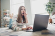 © deagreez - Surprised young woman at home reacts to unexpected news on laptop in cozy living room using natural daylight