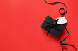 © Pixel-Shot - Gift box with blank paper tag and ribbon on red background. Black Friday sale