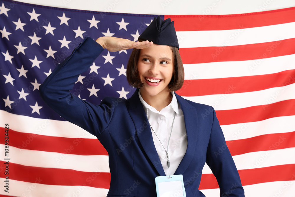 Young female stewardess with USA flag on beige background