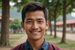 © ThomasLENNE - Close portrait of a smiling young Bhutanese man  school teacher looking at the camera, blurred background