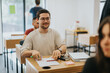 © qunica.com - Students sit at desks in a high school classroom, focused on their work. The setting conveys concentration, education, and a collaborative learning environment.