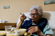 © ADDICTIVE STOCK - Senior Woman Enjoying Meal in Residential Care Setting