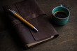 © ADDICTIVE STOCK - Top view of coffee cup and notebook on wooden table