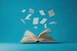 © andyaziz6 - An open book with pages flying up on a blue background.