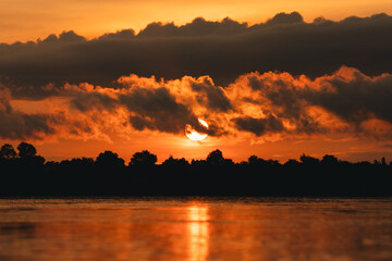 Wall Mural - beautiful landscape sunset, stunning view of the river and lake with orange and blue hues sky, trees