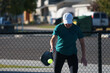 © Tedi S Photography - woman wearing white hat hitting the ball playing pickle ball on outdoor pickleball court